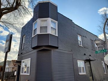 Chicago apartment for rent - A modern building with a grey facade and a sign that reads "BELL RD".