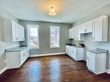 Chicago apartment for rent - A kitchen with white cabinets and a granite countertop.