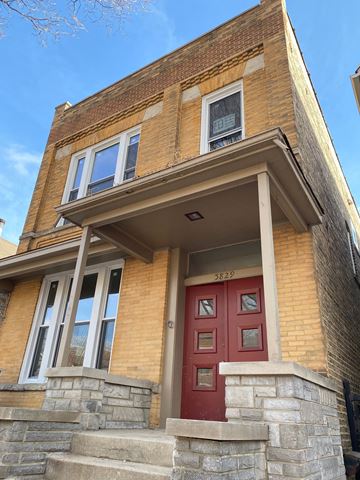 Chicago apartment for rent - A red door is on the front of a brown brick house.