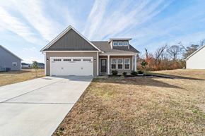 Richlands house for rent - A two-car garage with a brown roof and white walls is situated in a grassy area.
