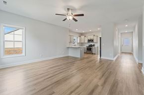 Richlands house for rent - A spacious room with a ceiling fan and wooden flooring.