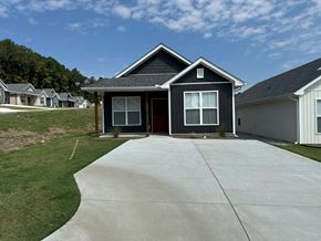 Little Rock house for rent - A house with a grey roof and a brown door is surrounded by other houses.
