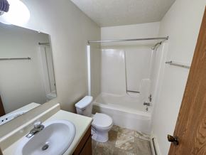 Lansing apartment for rent - A white bathroom with a toilet, sink, and bathtub.