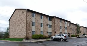 Lansing apartment for rent - A building with a parking lot in front of it.