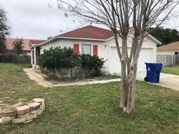 St Augustine house for rent - A white house with a red roof and a blue trash bin.