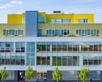 Chicago apartment for rent - A modern building with a yellow and blue section on top.