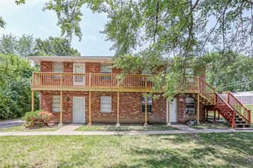 Independence apartment for rent - A red brick house with a porch and a staircase leading to the second floor.