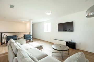 Los Angeles apartment for rent - A living room with a white couch and a television mounted on the wall.