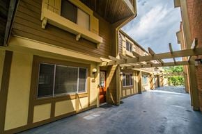 Boulder apartment for rent - A long hallway with a yellow building on the left and a brown building on the right.