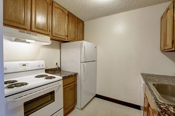 Boulder apartment for rent - a kitchen with white appliances and wooden cabinets and a white refrigerator