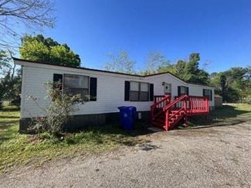 St Augustine house for rent - A white mobile home with a red staircase outside.