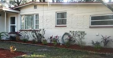 Orange Park house for rent - A white house with a red door and a small garden in front.