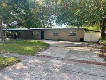 Orange Park house for rent - A house with a driveway and trees in the background.