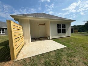 Little Rock house for rent - A small white house with a wooden door and windows is shown.