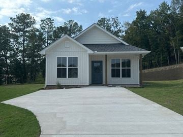 Little Rock house for rent - A small white house with a grey roof and a grey concrete walkway in front.