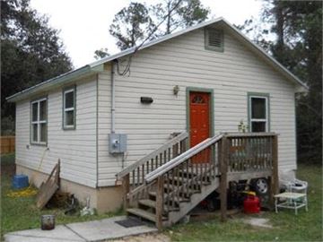 St Augustine house for rent - A small house with a red door and a wooden staircase leading to the door.