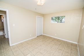 Denver apartment for rent - A room with a tiled floor and a window with a view of trees outside.