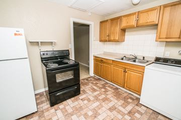 Denver apartment for rent - A kitchen with a black stove top oven and a white dishwasher.