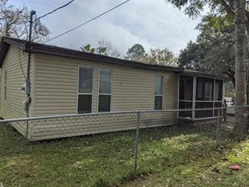 St Augustine house for rent - A beige mobile home with a porch and a fence.