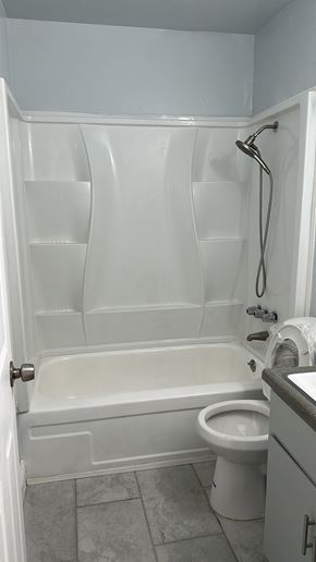 Fresno apartment for rent - A white bathroom with a toilet and a bathtub.