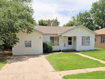 Littlefield house for rent - A white house with a brown roof and a green lawn in front.