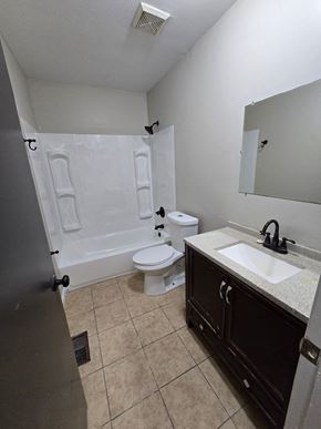 St. Louis house for rent - A bathroom with a toilet, sink, and shower.