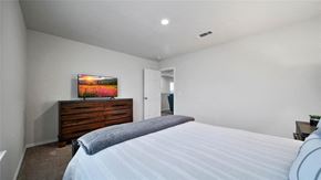 Katy house for rent - A bedroom with a bed, dresser, and painting on the wall.