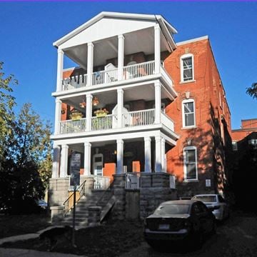 Ottawa apartment for rent - A two-story red brick house with a white balcony.