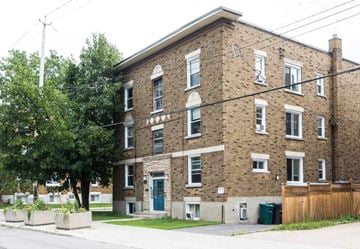 Ottawa apartment for rent - A brick building with a green door and windows.