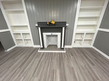 Thibodaux apartment for rent - A black shelf with a yellow object on it is in the middle of a room with grey walls and a grey floor.