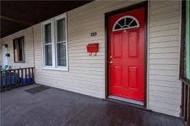 Munhall house for rent - A red door is on the right side of a white house.