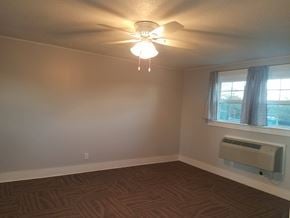 Hattiesburg house for rent - A room with a ceiling fan and a window with a curtain.