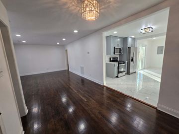 Gary house for rent - A kitchen with a refrigerator, microwave, and oven is visible through a glass door.