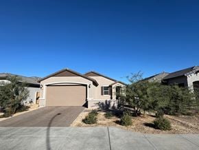 Tolleson house for rent - A house with a brown garage door is surrounded by trees and bushes.