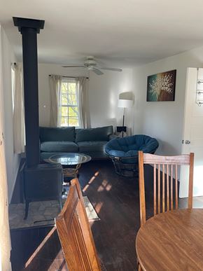 Hyampom house for rent - A living room with a wood stove and a blue chair.