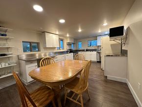 Sitka house for rent - A kitchen with a wooden table and chairs.