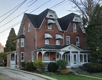 Royersford apartment for rent - A large red brick house with a black roof and white trim.