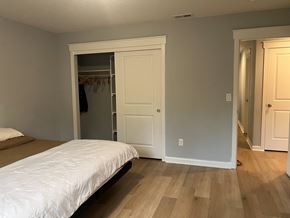 Kelso house for rent - A bedroom with a white bed and wooden floors.