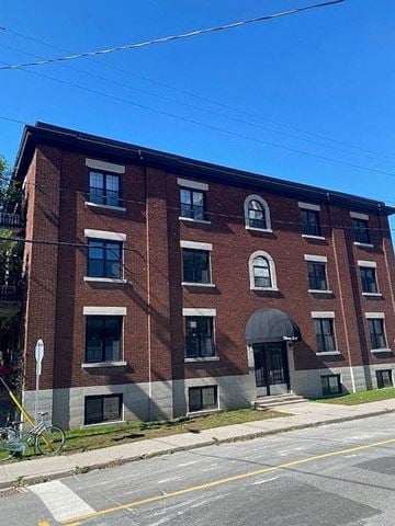 Ottawa apartment for rent - A red brick building with a black door and windows.