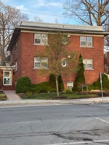 Ottawa apartment for rent - A red brick house with a tree in front.