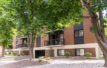 Ottawa apartment for rent - A building with a balcony is surrounded by trees.