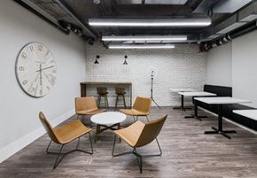 Ottawa apartment for rent - A large clock hangs on the wall above a table with chairs around it.