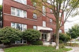 Ottawa apartment for rent - A red brick building with a tree in front.