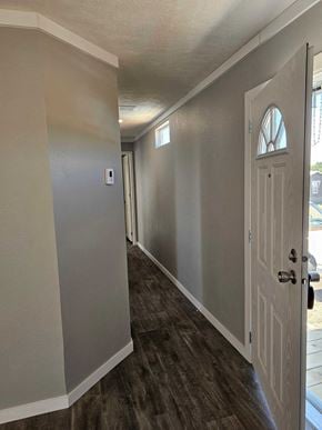 Guthrie house for rent - A hallway with a white door and a light switch on the wall.