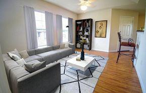 Lubbock apartment for rent - A living room with a grey couch, a white coffee table, and a black floor lamp.