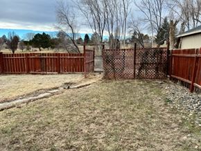 Grandview house for rent - A brown fence encloses a grassy area.