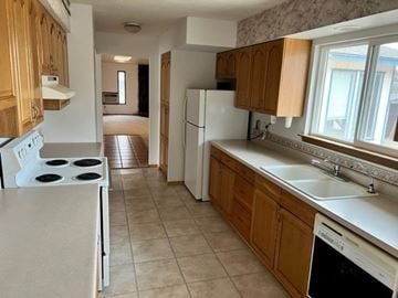 Grandview house for rent - A kitchen with a white stove top oven and a white dishwasher.