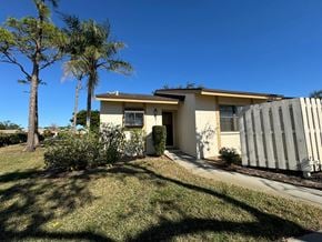 Bradenton house for rent - A house with a fence and a tree in front of it.