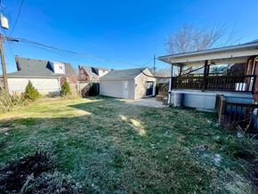 Louisville house for rent - A backyard with a white house and a brown fence.
