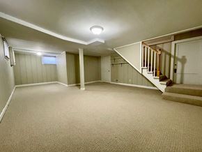 Louisville house for rent - A spacious room with a staircase and a window.